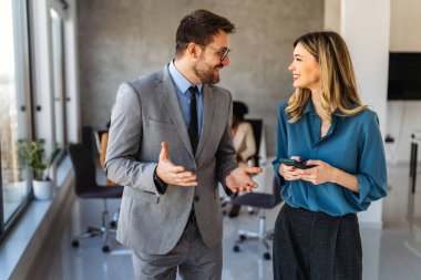 Tam konsantrasyon. Takım olarak çalışan ve kurumsal ofiste iletişim kuran bir grup genç iş adamı.