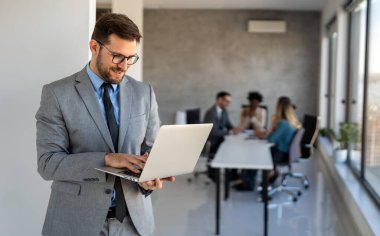 Ofiste dizüstü bilgisayar kullanan genç bir işadamı. Yönetici başarılı finansal fikirleri düşünür. Şirket için problem çözme çözümleri bulmak