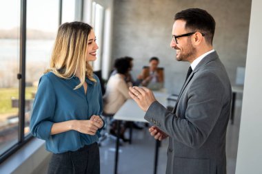 Modern ofis ortamındaki profesyoneller merdivenlerde işle ilgili konuları tartışıyorlar. Pozitif işbirliği, iş kıyafeti ve üretken bir ekip sahnesi.