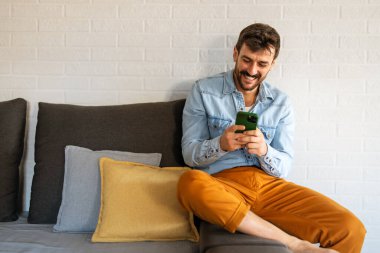 Akıllı telefon teknolojisi insanlarla iletişim konsepti. Genç adam cep telefonunu iş, sosyal medya veya rahatlama için kullanıyor