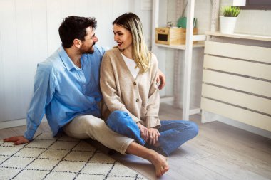 Sevgi dolu bir çift, evde birbirlerinin gözlerinin içine bakar. Duygusal güveni, açık iletişimi ve güçlü, mutlu bir ilişkiyi sembolize eder.