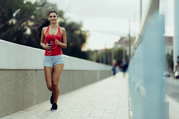 Vrouw joggen in stad — Stockfoto