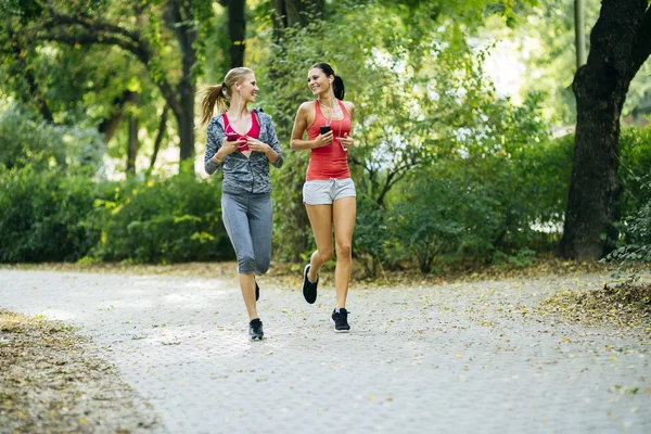 Energetic young women running outdoors — Stock Photo, Image