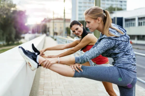 Mujeres estirándose antes de correr —  Fotos de Stock