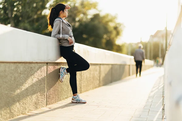 Schöne Frau ruht sich nach dem Joggen aus — Stockfoto