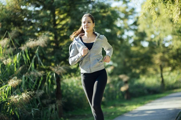 Vrouw rennend in park — Stockfoto