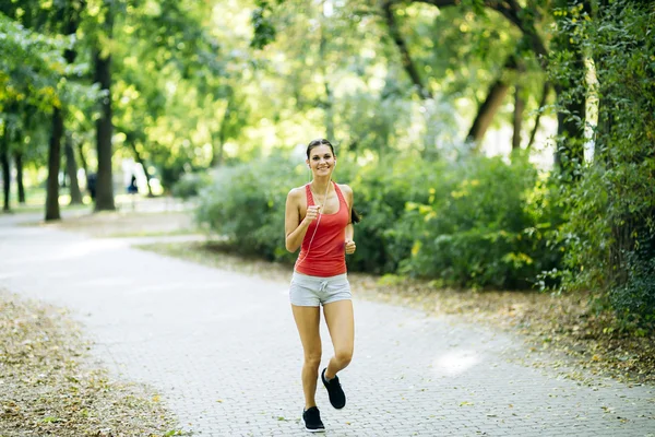 Jonge mooie atleet joggen in het park — Stockfoto