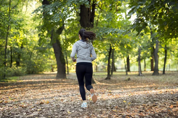 Спортивная женщина бегает в парке — стоковое фото