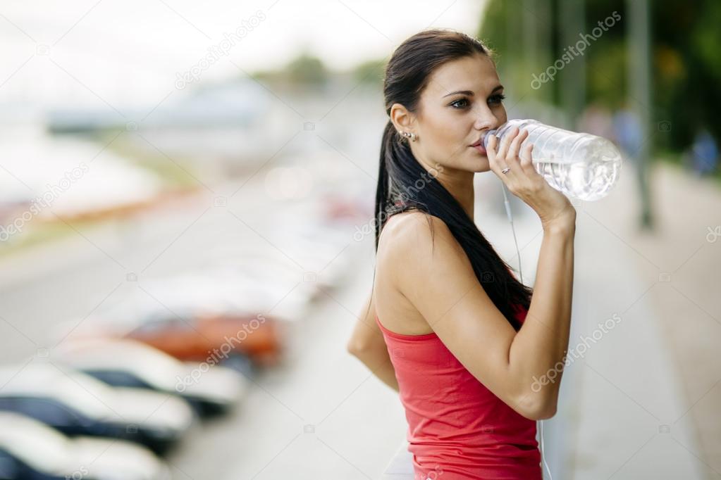 Thirsty woman drinking water to recuperate
