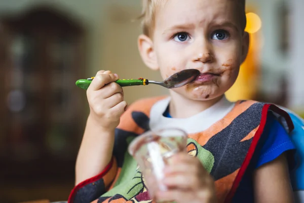 Размазанный ребенок ест — стоковое фото