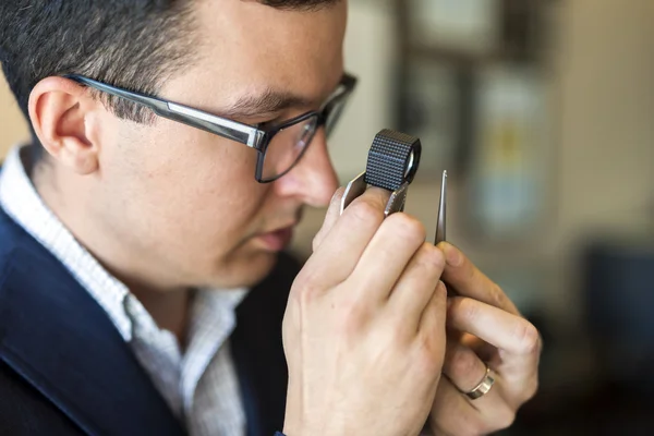 Jeweler looking at diamond through loupe — Stock Photo, Image