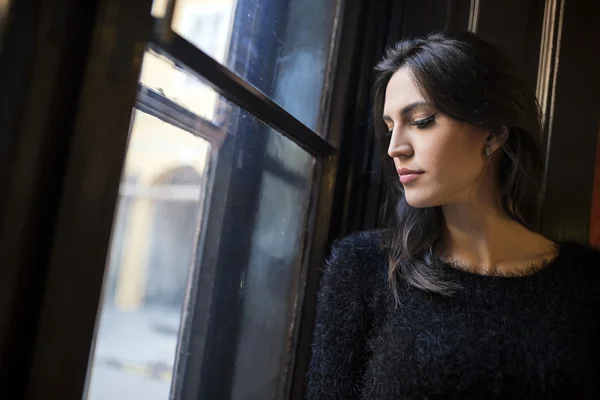 Pretty woman looking out the window — Stock Photo, Image