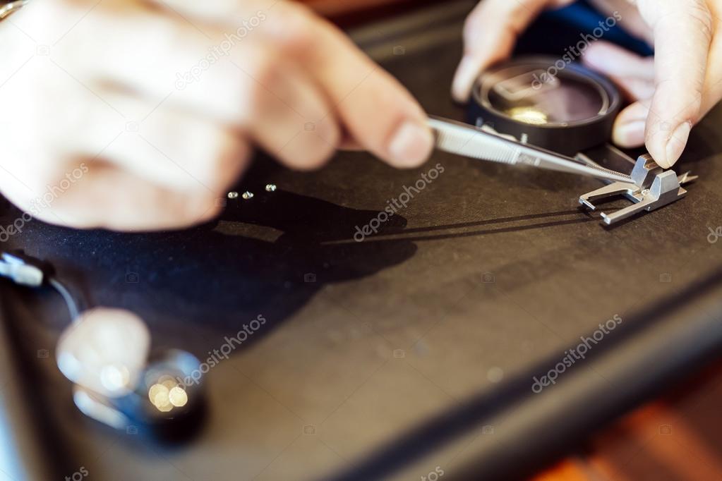 Jeweler checking size of diamond