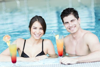 Yüzme havuzun kenarında bir kokteyl içme Çift