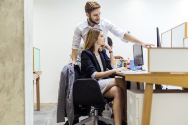 Bir ofiste PC'de çalışma arkadaşları