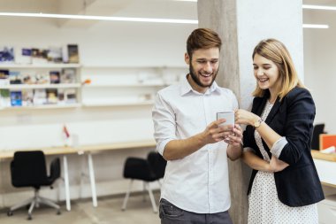 Telefonda bir ofiste, bakarken gülümseyen iş arkadaşları