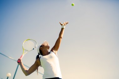 Beautiful female tennis player serving clipart