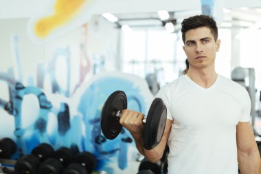 Yakışıklı adam spor salonunda ağırlık kaldırma