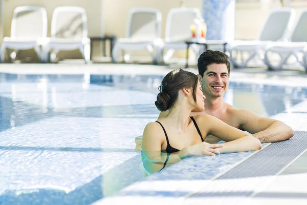 Couple relaxing by the side of the pool — Stock Photo, Image