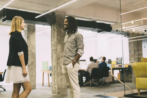 Colegas hablando en la oficina y sonriendo — Foto de Stock