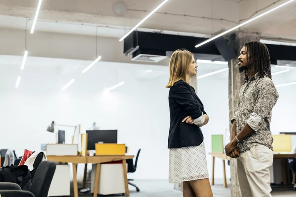 Colegas hablando en la oficina y sonriendo — Foto de Stock