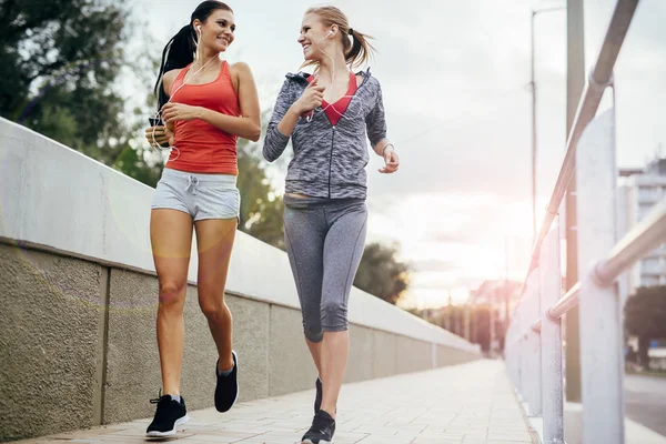 Dusk şehirde iki kadın joggers — Stok fotoğraf