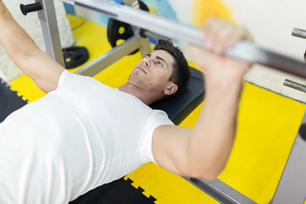 Bell'uomo che solleva pesi in palestra — Foto Stock