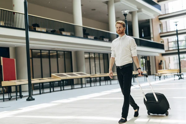 Knappe bedrijf houden een trolley — Stockfoto