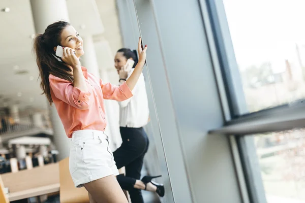 Mulheres usando telefones e conversando durante o intervalo — Fotografia de Stock