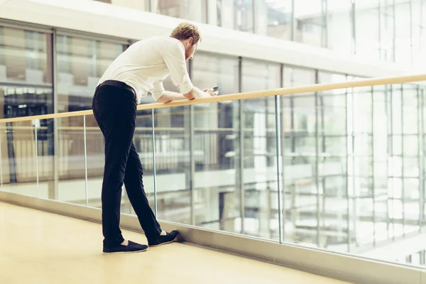 Uomo d'affari che tiene il telefono sul balcone — Foto Stock