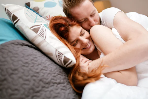 Coppia dai capelli rossi sorridente a letto — Foto Stock