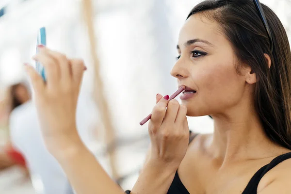 Hermosa mujer aplicando lápiz labial — Foto de Stock