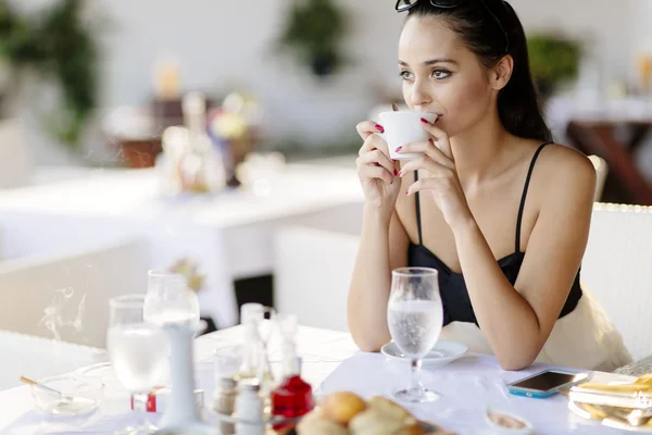 Woman drinking coffee in restaurant — Stock Photo, Image