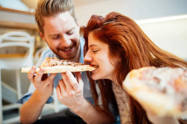 Pareja compartiendo pizza y comiendo — Foto de Stock