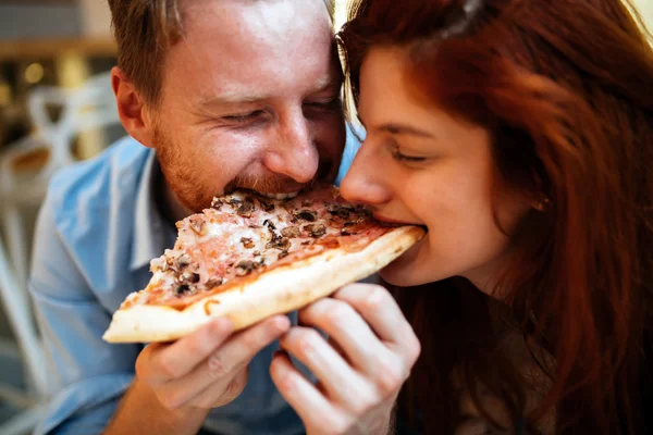 Couple sharing pizza and eating — Stock Photo, Image