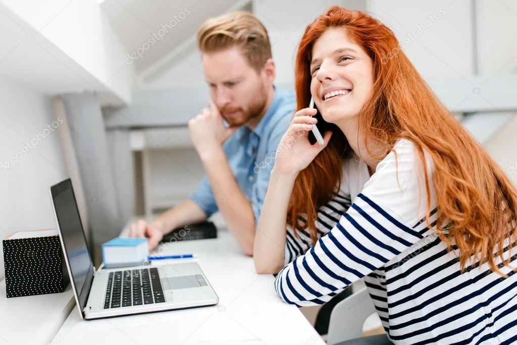 Ginger woman working in office with colleague