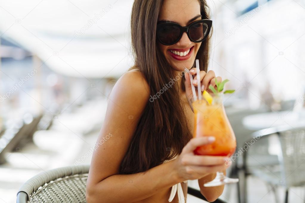 Sexy woman drinking cocktail in summer