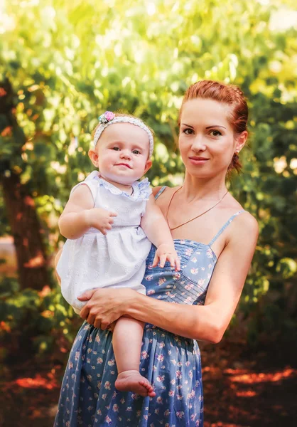 Mother with little daughter on hands in summer Park outdoors — Stock Photo, Image