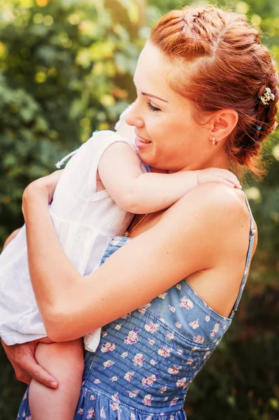 Madre con la pequeña hija en las manos en verano Parque al aire libre —  Fotos de Stock