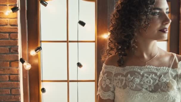 La chica en un vestido de novia sonriendo y mirando de lado a lado — Vídeos de Stock