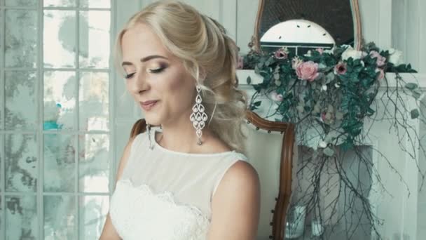 Девушка в свадебном платье улыбается и смотрит из стороны в сторону — стоковое видео