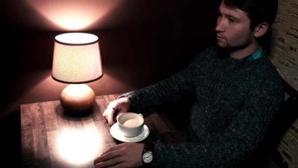 El tipo en la mesa bebiendo café — Vídeo de stock