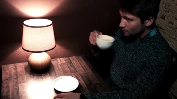 Man zit aan de tafel drinken koffie — Stockvideo