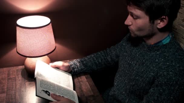 Le type au bureau lisant un livre — Video