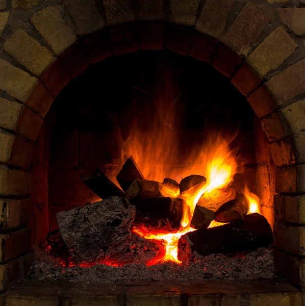 En eld brinner i öppen spis. — Stockfoto