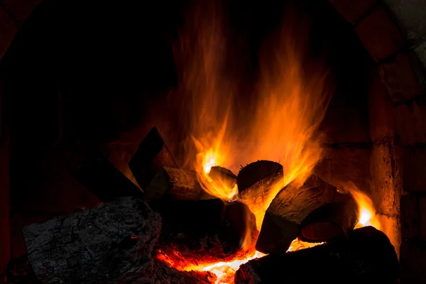 Un fuego arde en una chimenea . — Foto de Stock