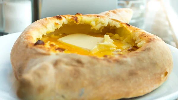 Adjaruli khachapuri, cheio de queijo e coberto com um cru, por exemplo — Fotografia de Stock