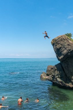 Tsikhisdziri, Gürcistan - 07 Ağustos 2020: Yüksek kayadan Georgia 'ya atlayan adam. Karadeniz