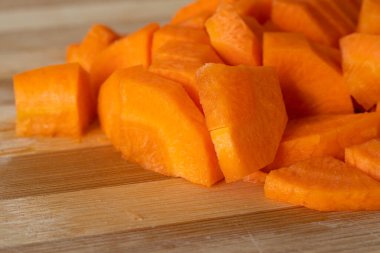 Tahtaya kesilmiş taze havuç yığını. Yiyecek.