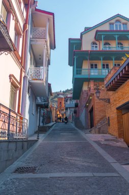 Tiflis, Gürcistan - 03 Nisan 2021: Eski Tiflis kasabasında ahşap oymalı balkonlu renkli geleneksel evler.